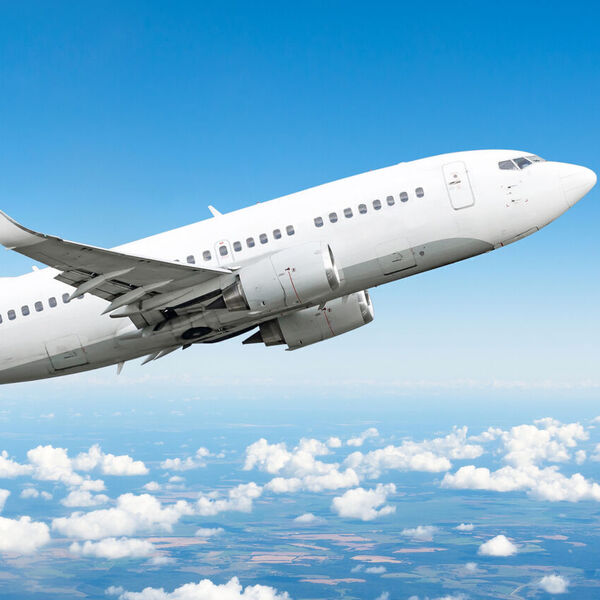 Airplane flying in blue sky with clouds