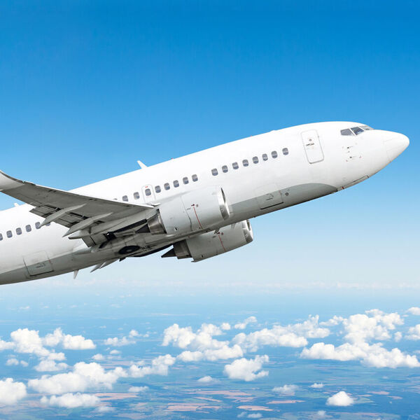 Airplane flying in blue sky with clouds