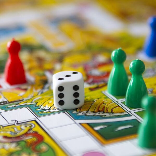 Board game with colorful playing pieces and a dice 
