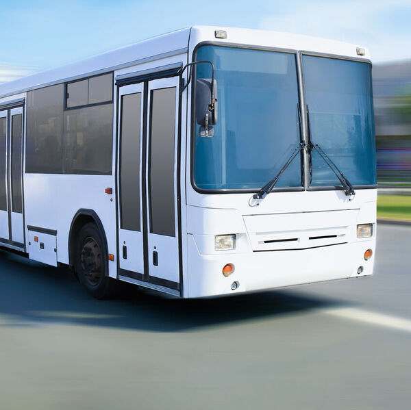 White bus driving down the road