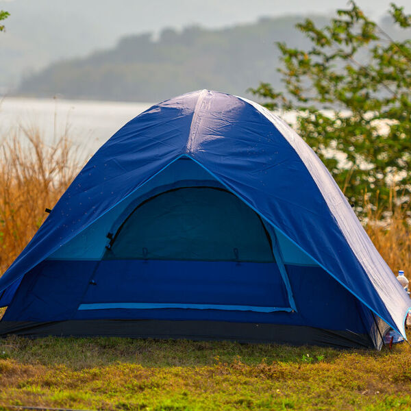 Blue tent in front of a lake