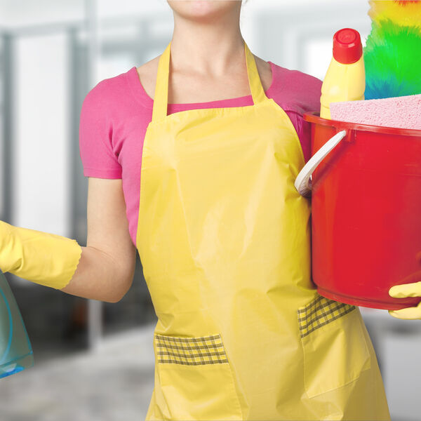 Woman in a yellow  apron and gloves with a bucket full of cleaning supplies