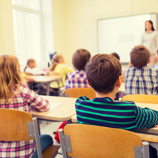 Elementary school students listening to the teacher in a classroom