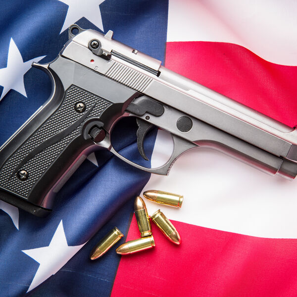 A gun and bullets on top of an American flag