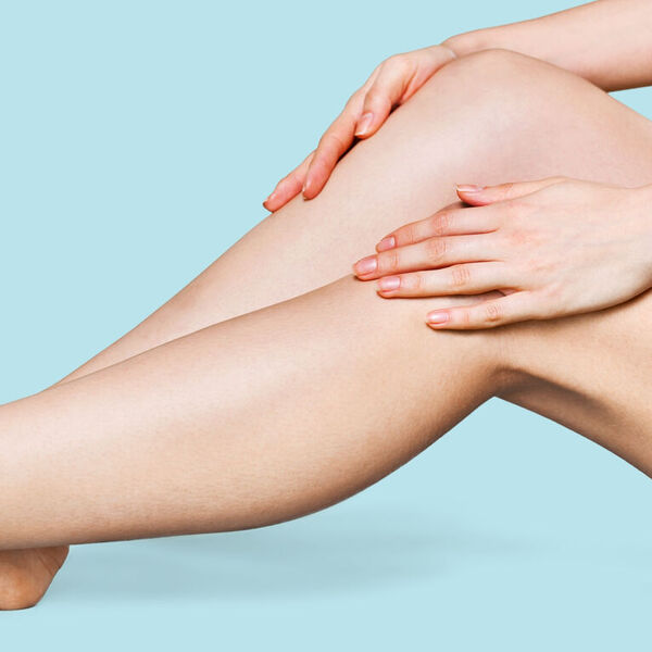Woman with hairless legs infront of a light blue background