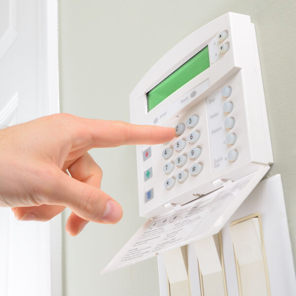 Person pressing a button on their home security system