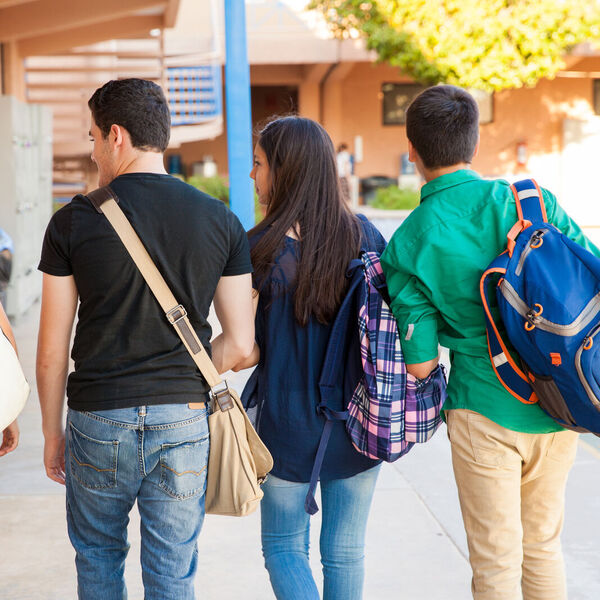 A group of middle school students walking down the hallway at school