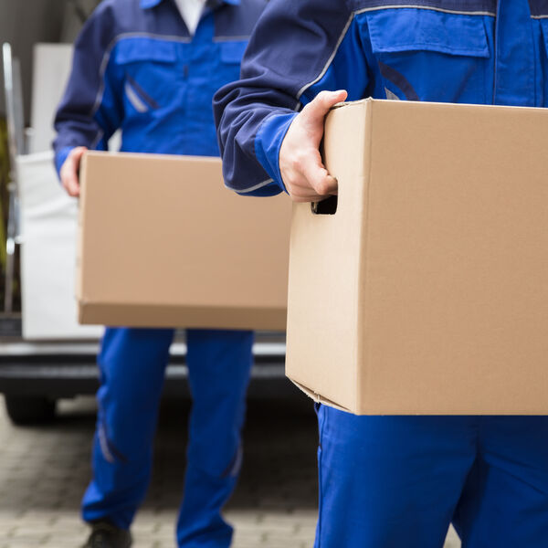 Two movrers in blue uniforms holding boxes