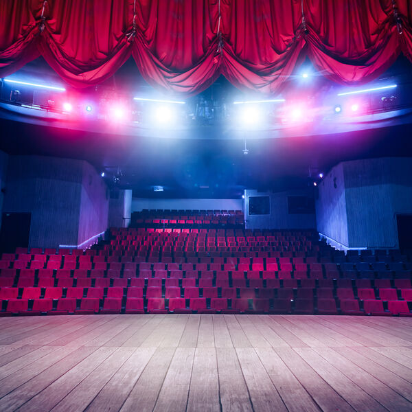 Stage with lights on and red empty seats