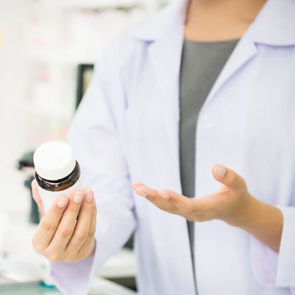 Woman pharmacist holds a bottle of medicine