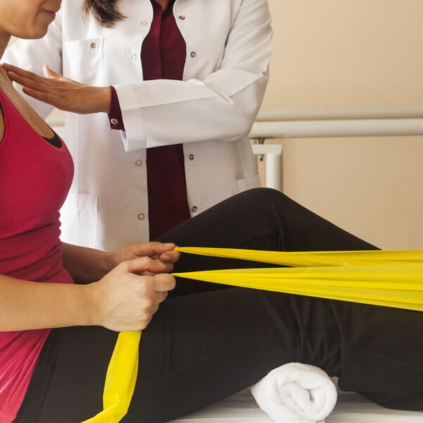 Woman physical therapist helping woman patient