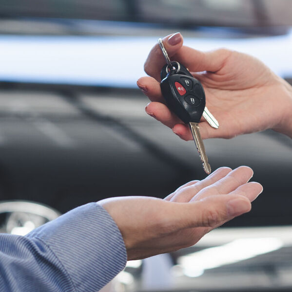 Woman handing man car keys