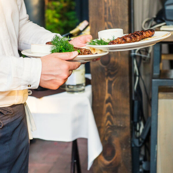 Male server bringing two plates of food out 