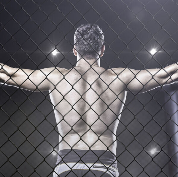 MMA fighter in cage celebrating win