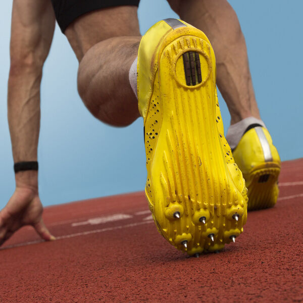 Male sprinter with shorts on and yellow shoes