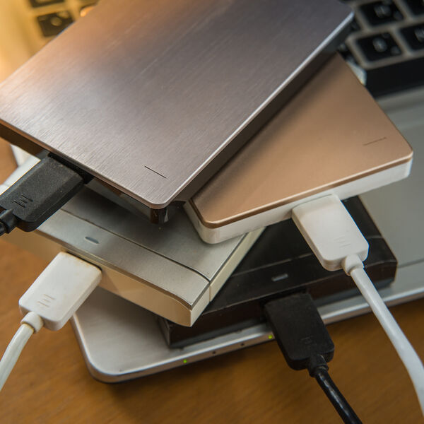 Four different colored storage devices on top of a laptop