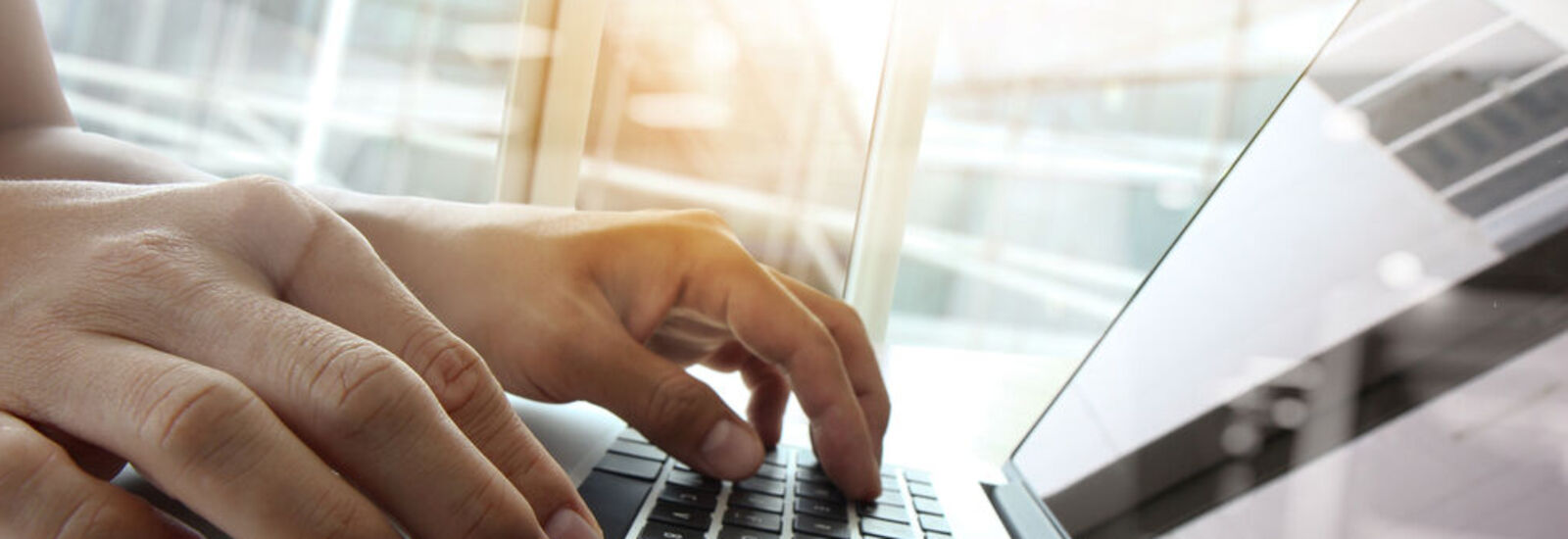 Man typing on laptop on table 